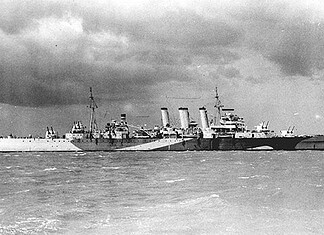 Degaussing van scheepsrompen en magnetische mijnen Brits zwaar kruiser HMS Norfolk op zee, stalen romp zichtbaar, voorbeeld van schip met magnetische signatuur tijdens oorlog