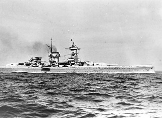 Admiral Scheer: Duitse zware kruiser 1934-1945 Admiral Scheer op zee met de aangetreden bemanning in paradeopstelling aan dek, gezien vanaf de stuurboordzijde van het schip