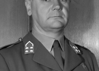 Hendrik Johan Kruls en het Militair Gezag Portret van generaal H.J. Kruls in zijn werkkamer, zittend achter zijn bureau en gekleed in militair uniform.